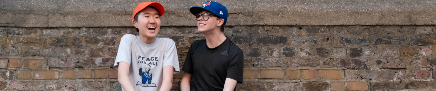 Two young people laughing outdoors.