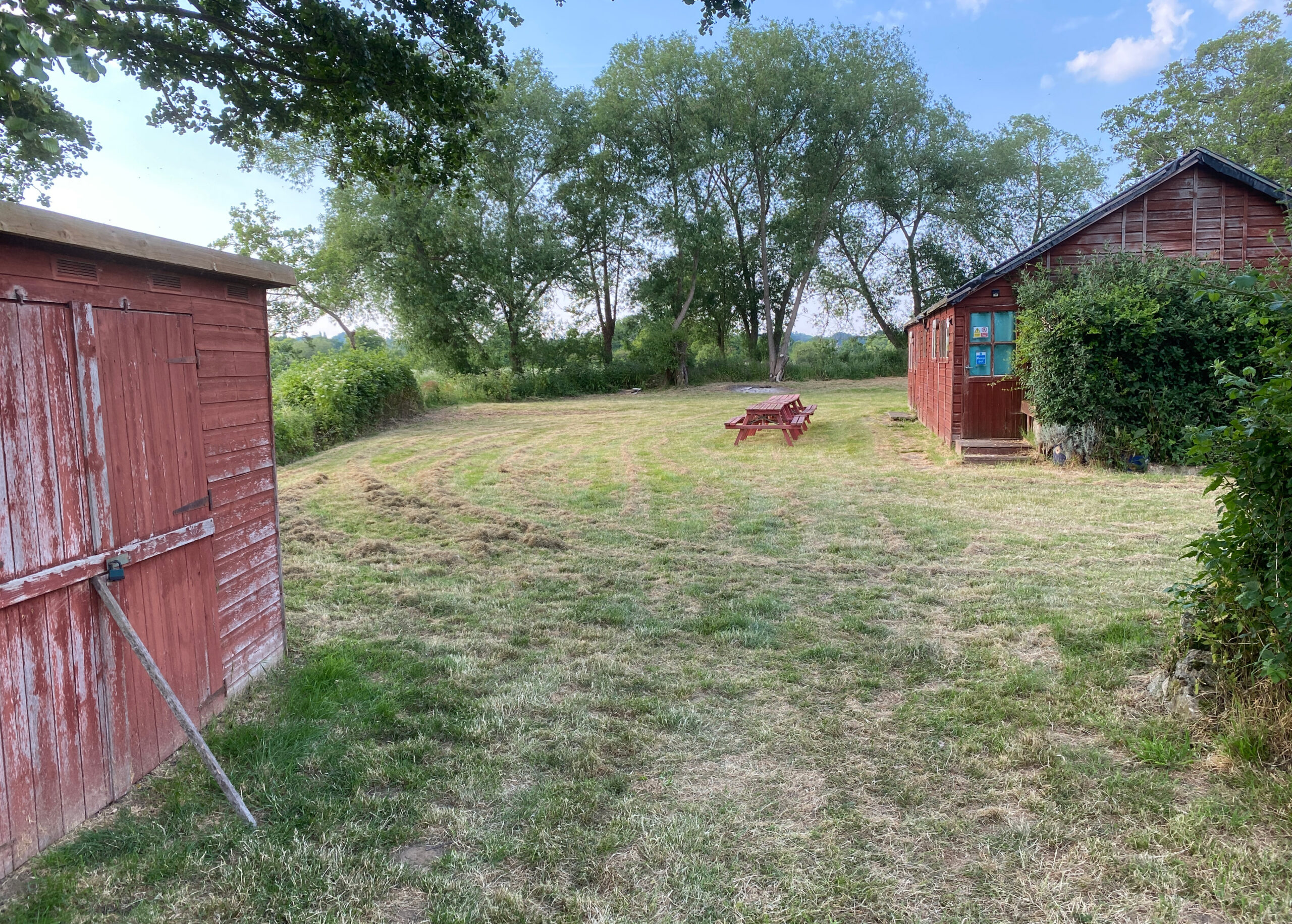 2 wooden sheds in a yard.